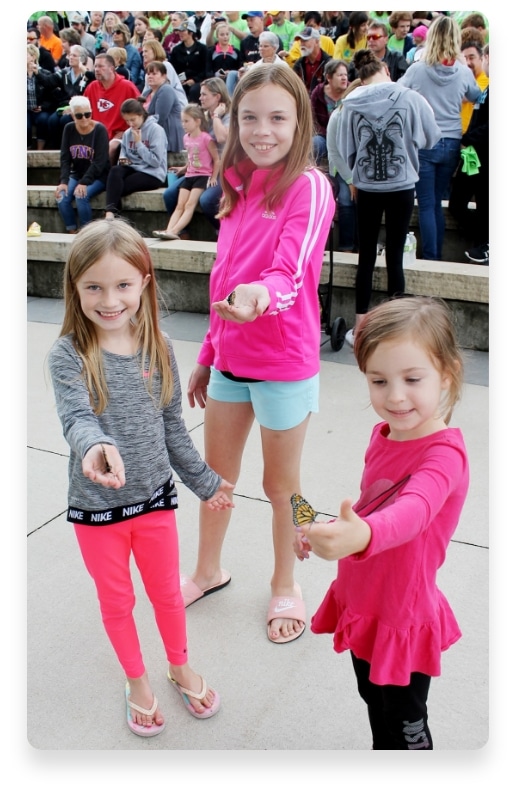 young girls holding monarch butterflies