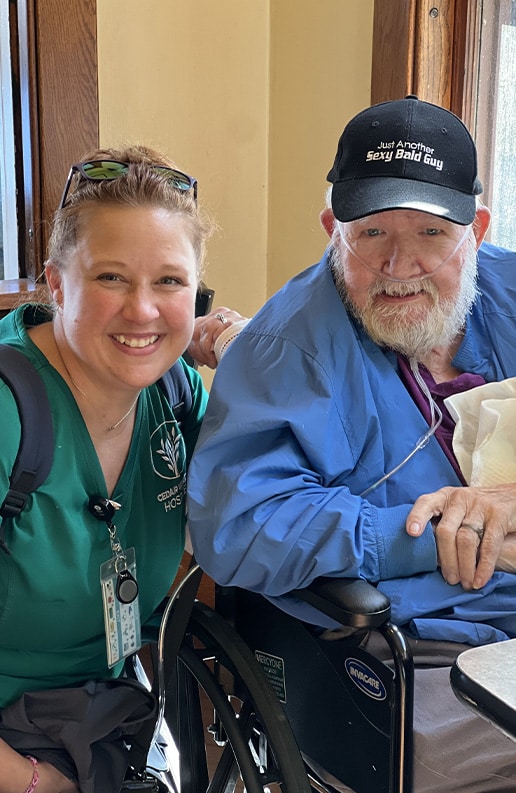 nurse kneeling next to man in wheelchair