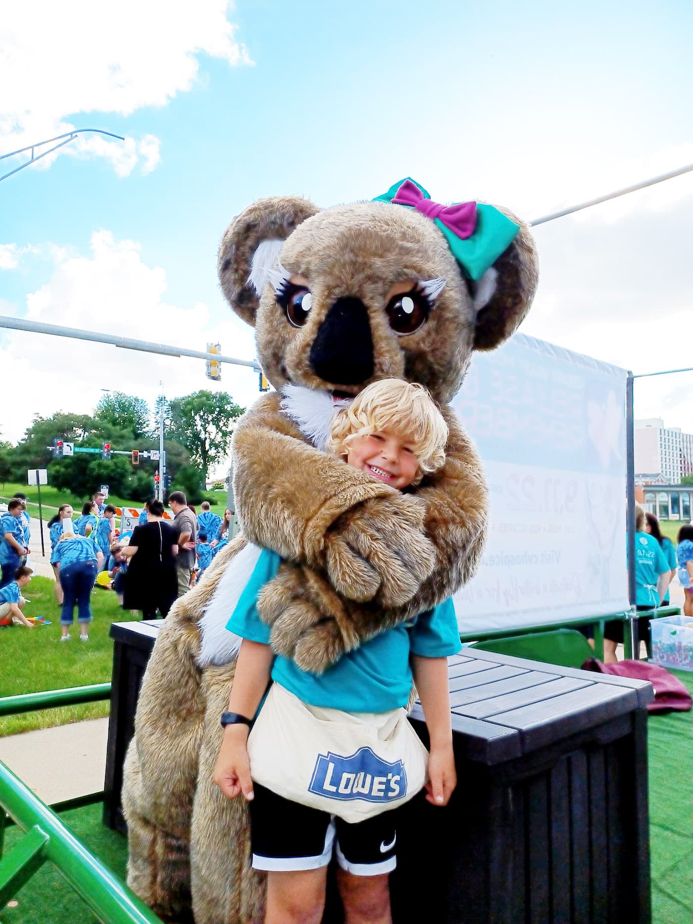young boy being hugged by Koala mascot