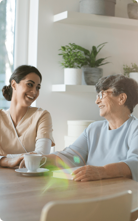 nurse and woman at table smiling and talking