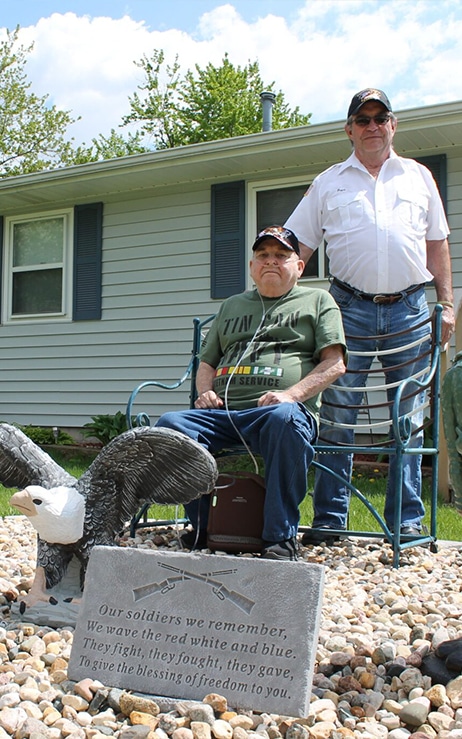 Two elderly veteran friends taking a photo outside