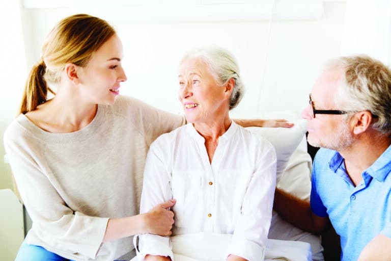Happy Family Visiting Senior Woman at Hospital