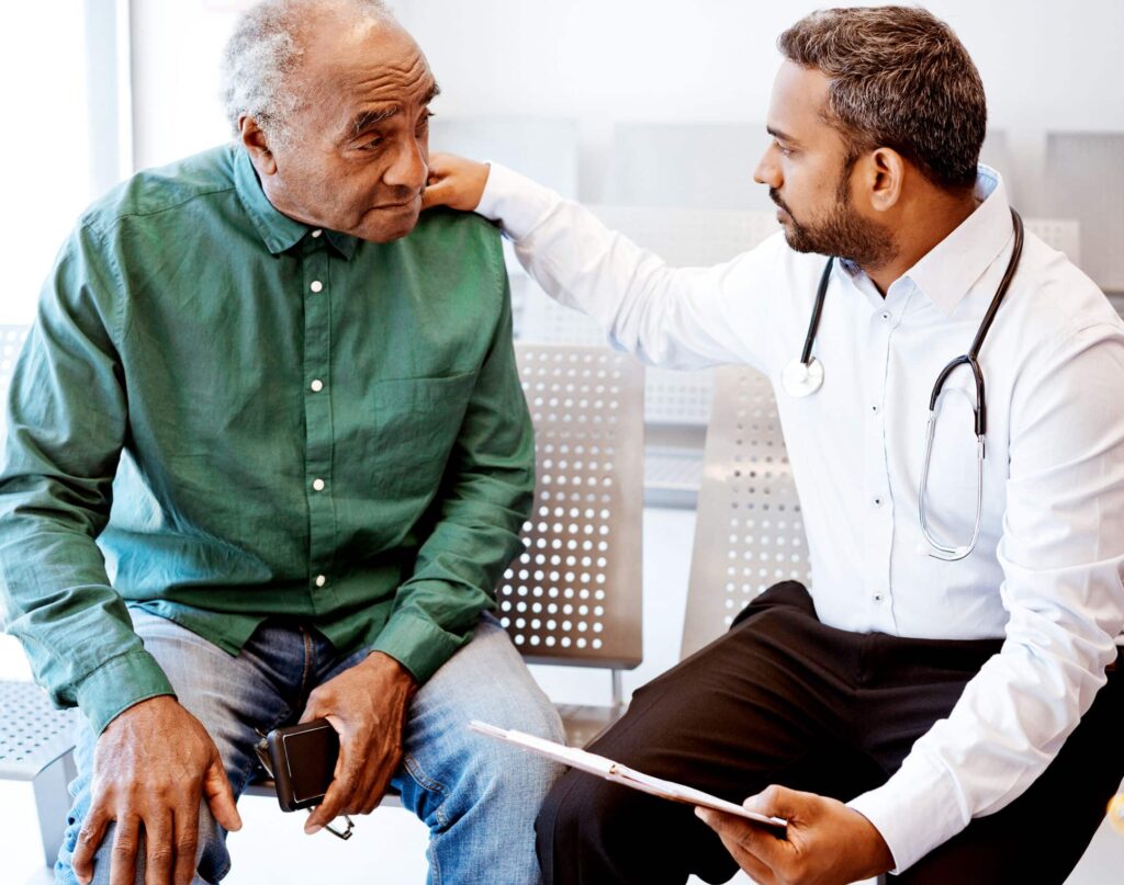 Doctor consoling sad senior male patient