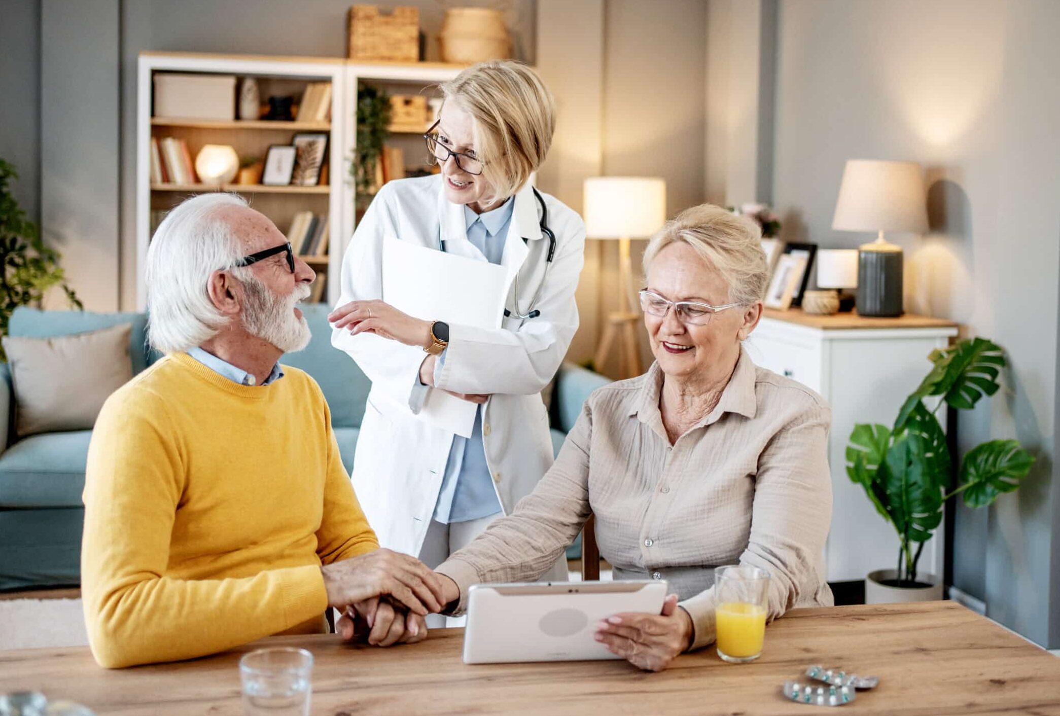 Senior couple reviewing medical information with female doctor on tablet