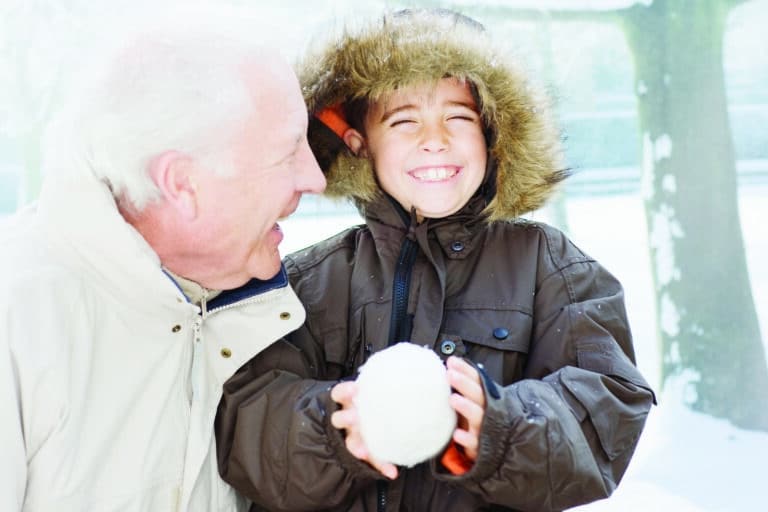 Grandfather and grandson holding snowball