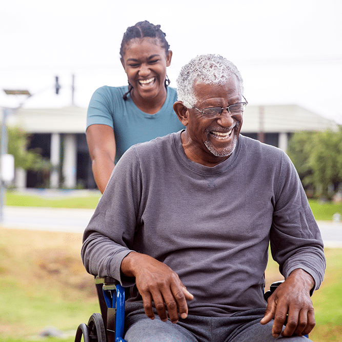 Daughter pushes father in wheelchair